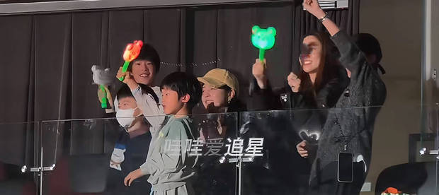 两家人一起挥动应援棒，画面温馨。